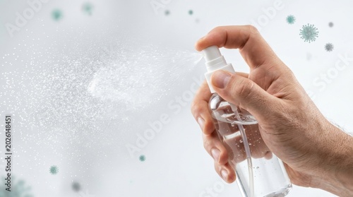 Hand holding clear spray bottle white.