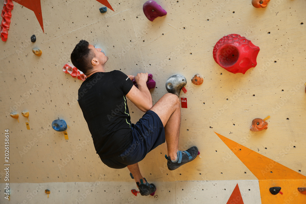 © New Africa - Athletic young man climbing wall in gym © New Africa - Athletic young man climbing wall in gym