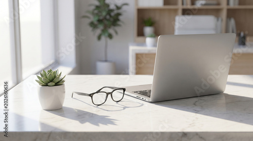 Opened laptop, eyeglasses, and a small succulent plant in a white pot on a marble desk in a bright office near a window