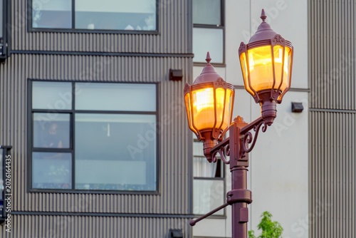 Photos Warm streetlights glow beside a modern apartment building