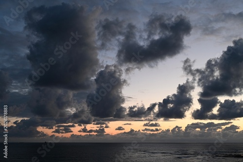 Bilde på lerret Dramatic sunset clouds over ocean horizon with darkening sky