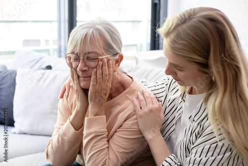 Photos Granddaughter Comforting Elderly Woman At Home Showing Compassionate Family Care