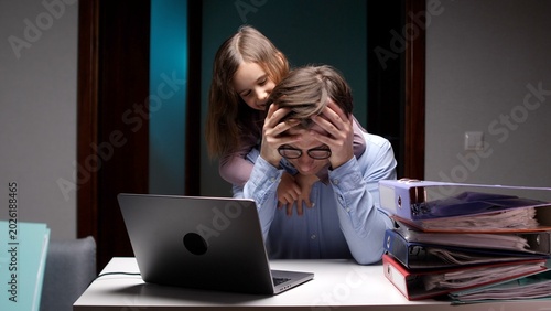 Foto Overwhelmed father working late on laptop in home office, burned out and stresse