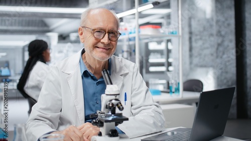 Billede på lærred Portrait of joyous researcher analyzing genetic samples with high tech microscopic equipment in laboratory