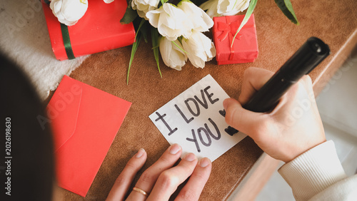 Slika na platnu Woman’s hand writing “I Love You” on paper