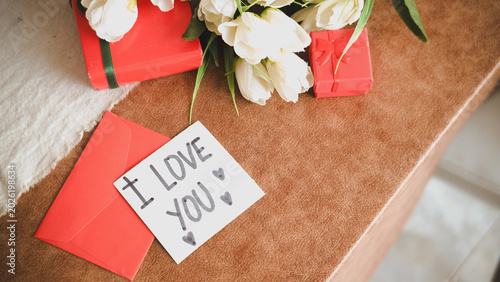 Fotografía Paper with “I Love You” written on it surrounded by gifts and flowers