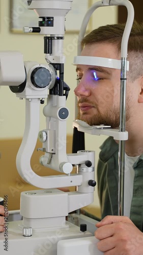 Young man undergoing eye examination with a slit lamp