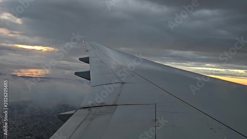 An airplane wing at dawn above the clouds during a flight to Buenos Aires. A view of Buenos Aires from above the clouds.
