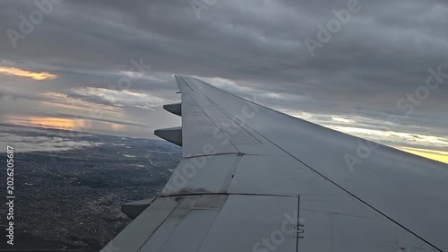 An airplane wing above the clouds at dawn on a flight to Buenos Aires. A view of Buenos Aires early in the morning at dawn.
