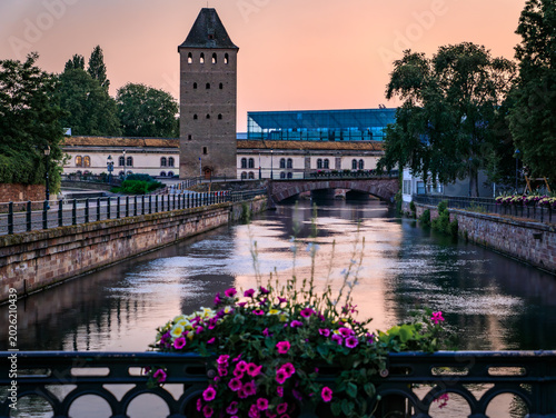 Tableau sur toile Blooming flowers Ponts Couverts Covered Bridges in Strasbourg, France at sunset