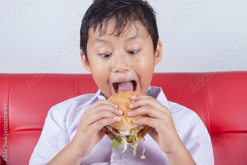 Foto Funny Boy Opening Mouth Wide to Eat a Big Hamburger