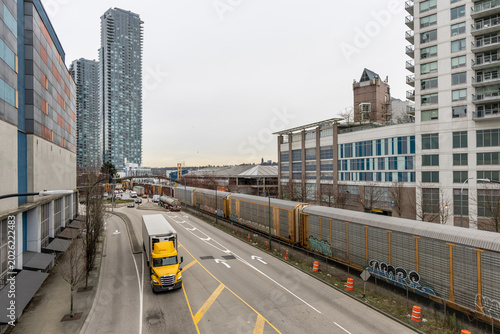 Urban Highway and Freight Train Passing Through New Westminster Cityscape Near Downtown Vancouver, BC, Canada