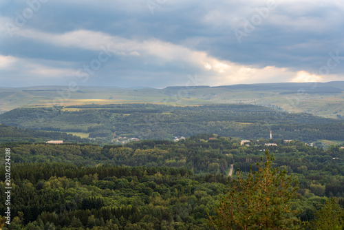Layers of green mountains and hills in the haze during sunset. Panoramic View of Green hills and Meadow.