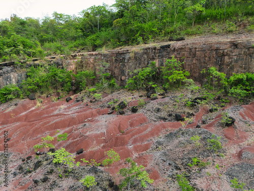 Eroded red soil patterns in an abandoned quarry after heavy rain