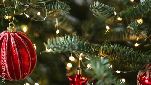 Christmas Season.A Christmas tree with decorations in red, silver, and white tones. shiny red baubles and silvery stars on the branches of a Christmas tree, with the glowing bokeh. 4k footage