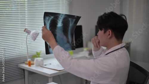 Medical professional examining chest X-ray in clinical consultation room