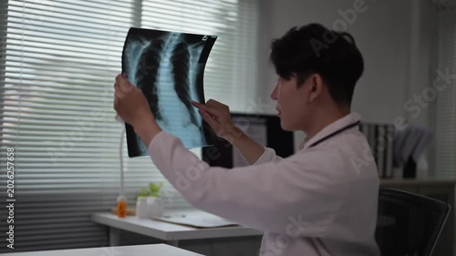 Medical professional examining X-ray film of human chest lungs in clinic setting