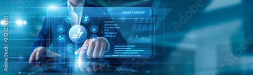 Foto Energy Engineer touching the tablet using Smart Energy, displayed diagrams and graphs with icons of smart grids, efficiency, renewable integration across the world map