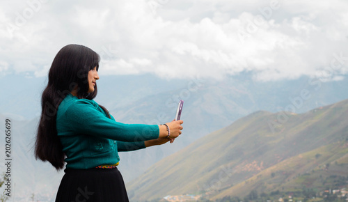 Tableau sur toile Mujer campesina atractiva en América Latina, feliz mientras usa un teléfono inteligente mirada a un espacio  publicidad y aislada en un fondo naturaleza