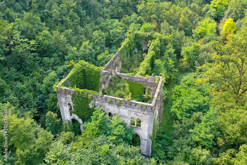 Konstfotografi Aerial drone view of the abandoned Ex Centrale Idroelettrica Rovereto power plant ruins surrounded by dense forest near Rovereto, Italy