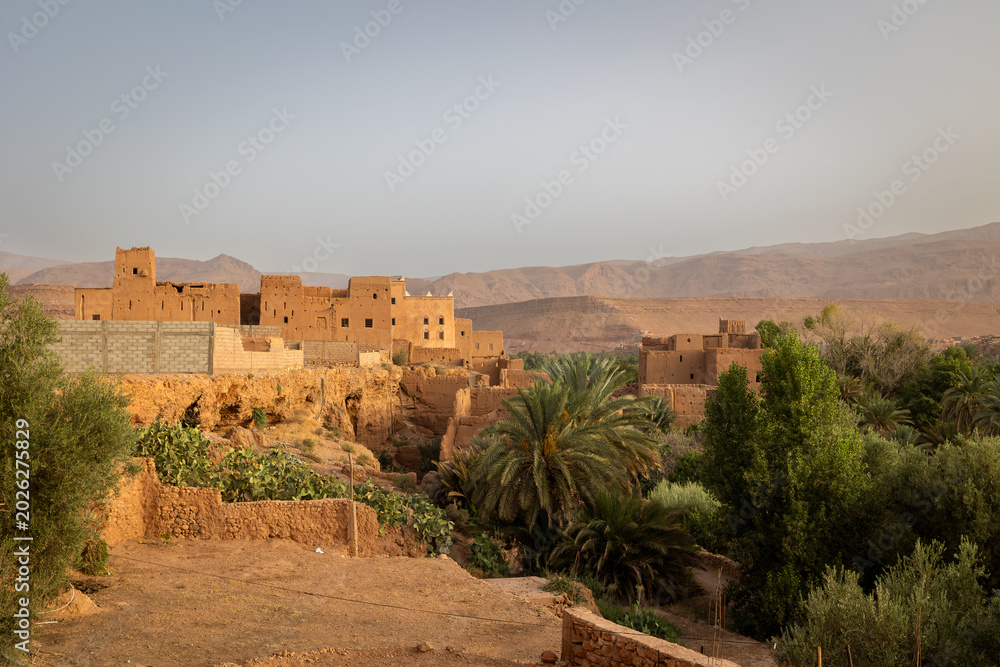 Fototapeta premium Ancient Berber kasbahs made of red clay and prickly pears in Dades Valley, Morocco.