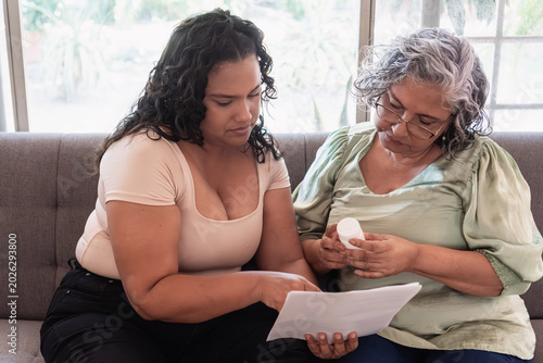 Caregiver assisting elderly woman managing medication