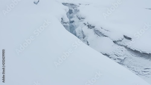 POV walking view approaching a huge deep crevasse opening in a glacier under Mera Peak summit in the Himalayas, Nepal. Dangerous ice fracture on a mountaineering route. 4K