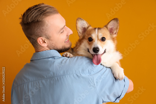 Young man with cute Corgi d...