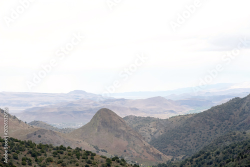 Panoramic landscape of mountains along the Nevada California border. Hazy clouds in sky