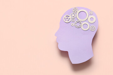 Paper human head with gears on pink background. World Mental Health Day