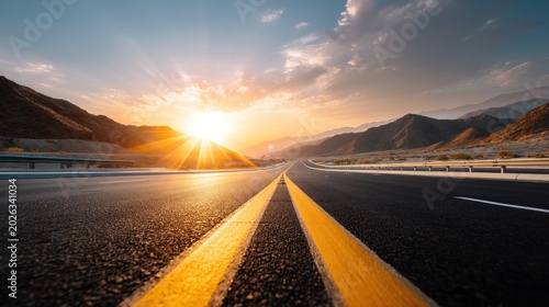 Scenic Sunrise Over Open Highway in Mountains with Vibrant Sky and Road Markings