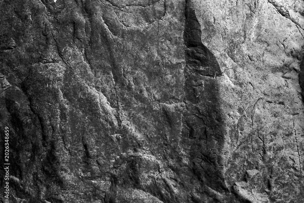 Fototapeta premium Dark rough rock texture with natural stone patterns and gritty surface details for backgrounds