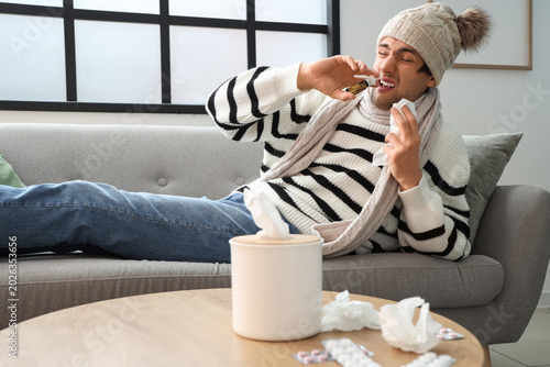 Sick young man in hat with ...