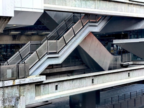 Modern brutalist architecture with complex geometric staircases and escalators