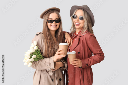 Young sisters with cups of ...