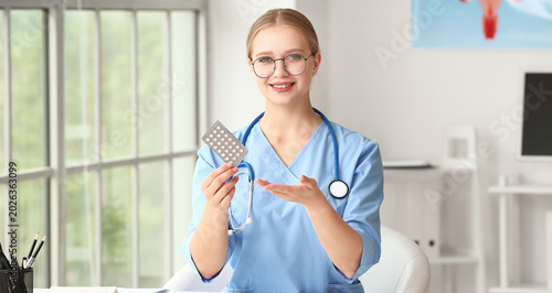 Female gynecologist with birth control pills in clinic