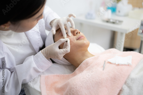 Foto Gentle hands perform precise facial treatment with tools