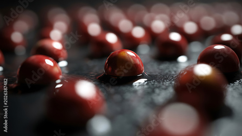 Closeup of shiny red candies on a dark surface with bokeh lights in the background creating a festive atmosphere for sweets and treats