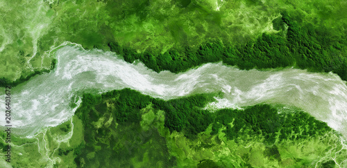 Aerial View of a Winding River: An expansive aerial perspective reveals a powerful, winding river cutting through vibrant, lush green forest canopy, showcasing nature's raw beauty.