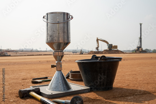 Bilde på lerret Soil Compaction Test Equipment: A cone and slump test apparatus sits on a construction site, ready for soil density analysis