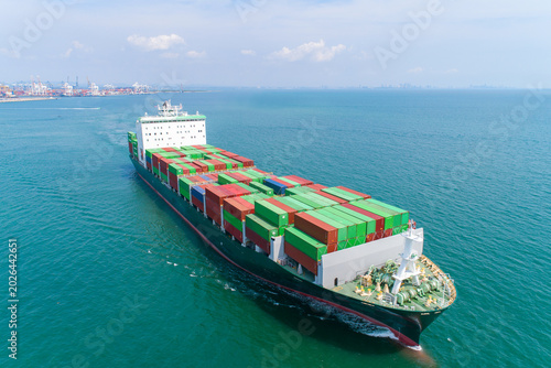 Canvas Print Massive Container Ship Navigating the Ocean: A colossal container ship, laden with stacks of colorful cargo containers, cruises through the vast blue expanse of the ocean
