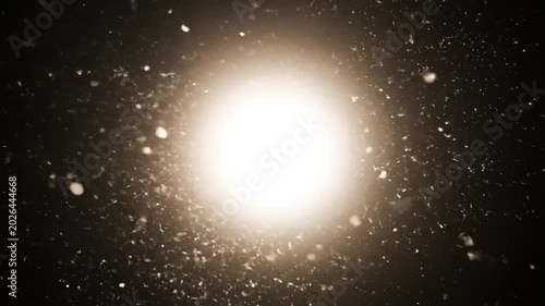 Abstract golden light particles glowing and floating in dark space background.