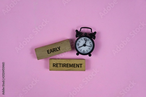 Early Retirement Concept With Alarm Clock On pink Background Representing Time And Financial Freedom.