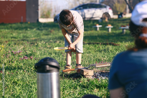 a boy at a picnic preparing food