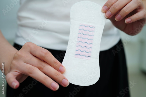 Obraz na plátně Asian woman holding sanitary napkin pad for hygiene menstrual period cycle protection