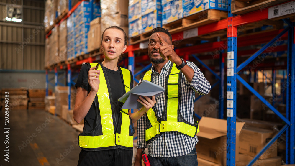 Obraz premium Warehouse manager talking and checking product in warehouse.