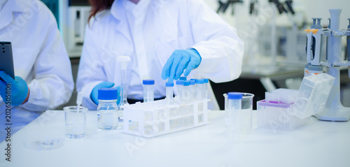 Biomedical scientists using pipettes and test tubes in a modern laboratory, advancing healthcare, biotechnology,