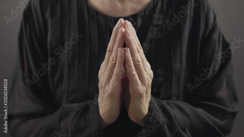 Praying hands on dark background