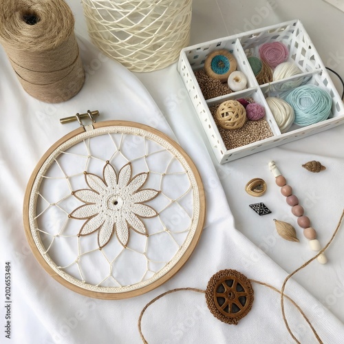 Handmade embroidery hoop floral design with crafting supplies on white background