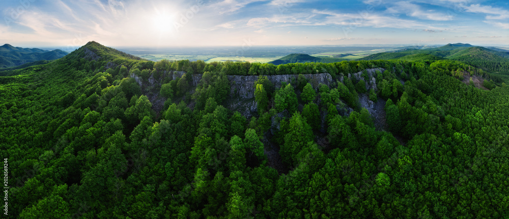 Fototapeta premium Colorful sunset in the mountains of the Little Carpathians in Slovakia with fresh green grass and leaves on the trees in the valley, spring evening